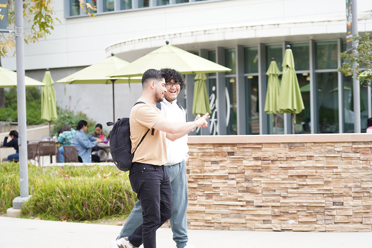 two male student walking and talking in the mid quad