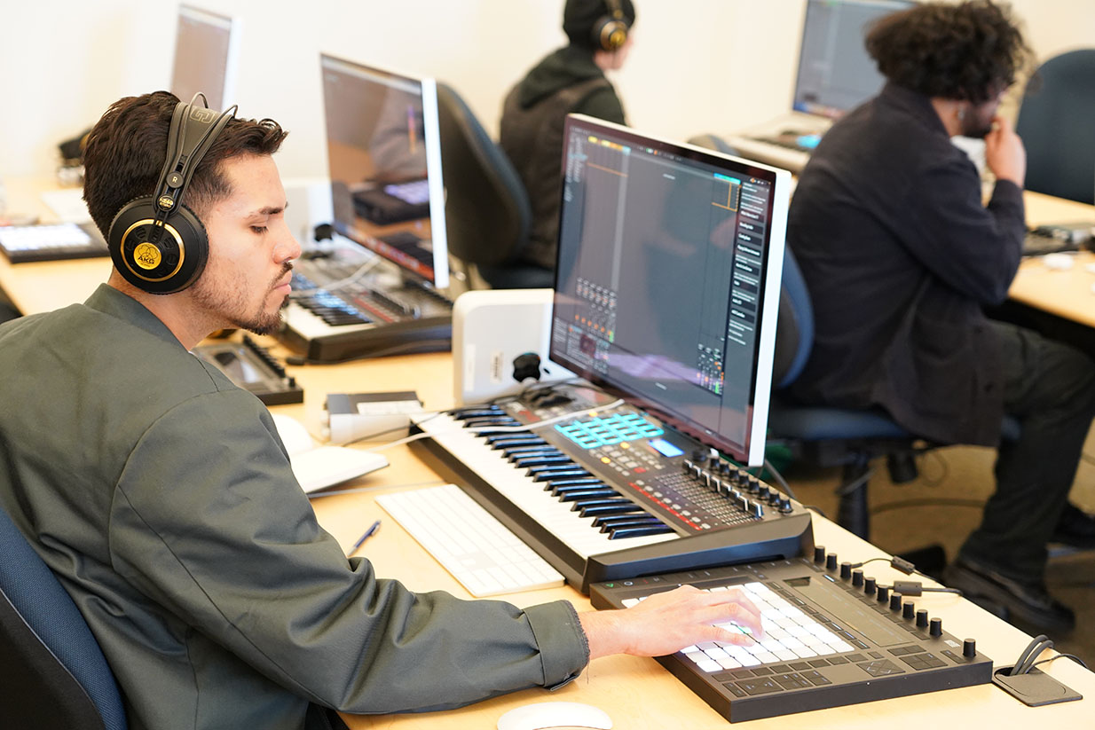 male student with headphones on taking an EDI class