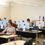 female student with headphones on taking an EDI class