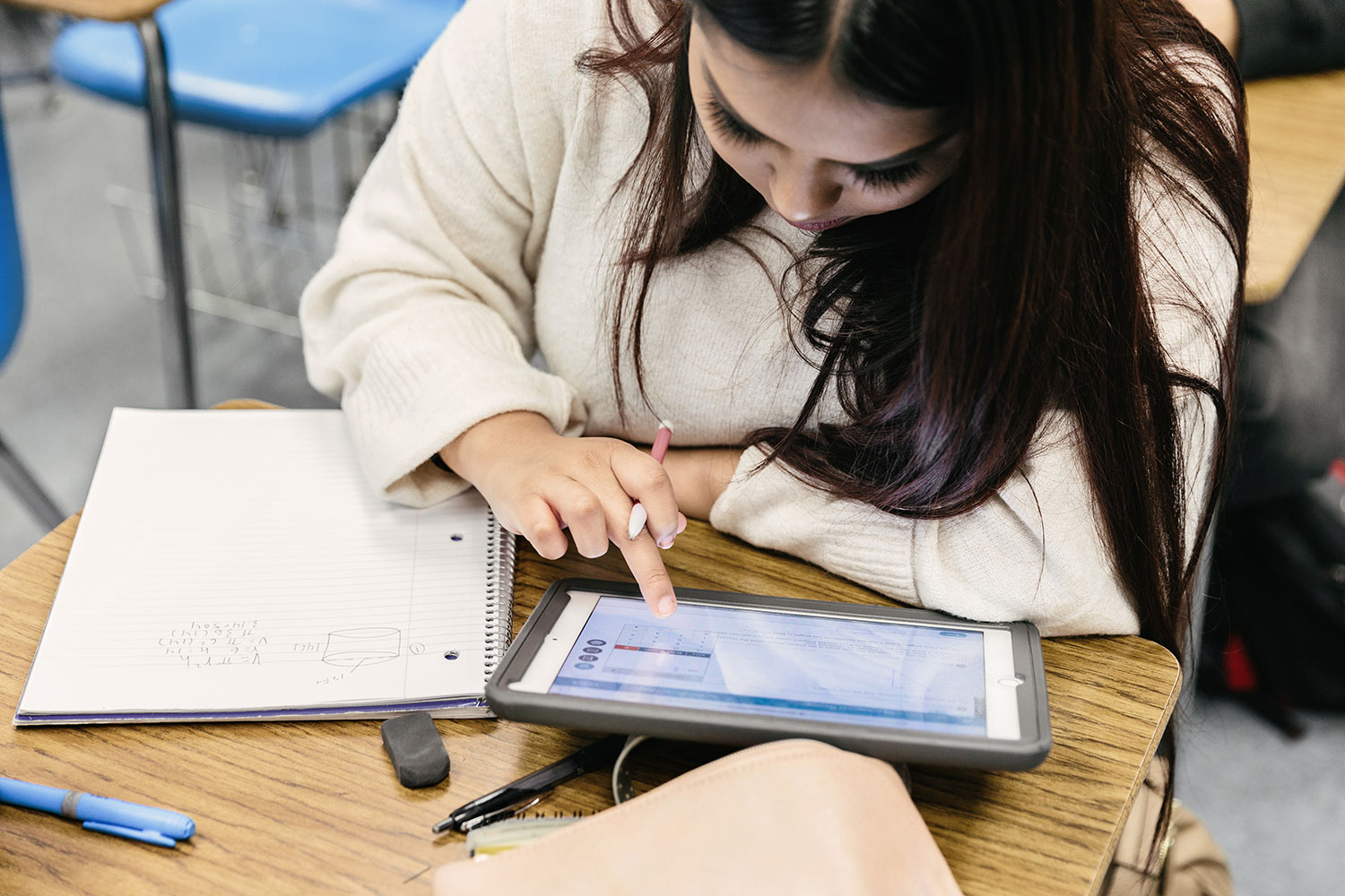 Girl uses an iPad to study at a desk