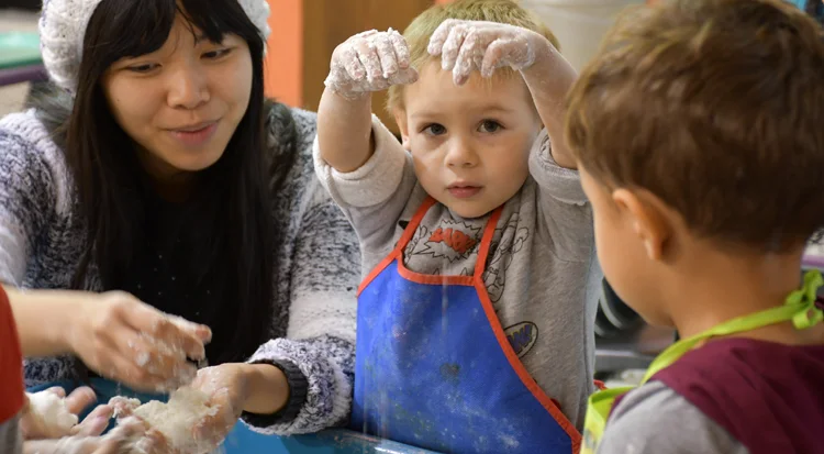 care taker playing flour with two children