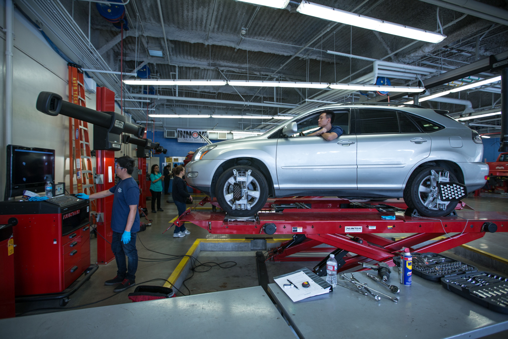 Brightly lit automotive garage with cars on lifts, showcasing Río Hondo’s advanced facilities for hands-on learning