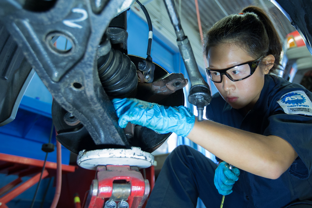 Close-up of a Río Hondo Community College automotive student inspecting a car inside the automotive lab