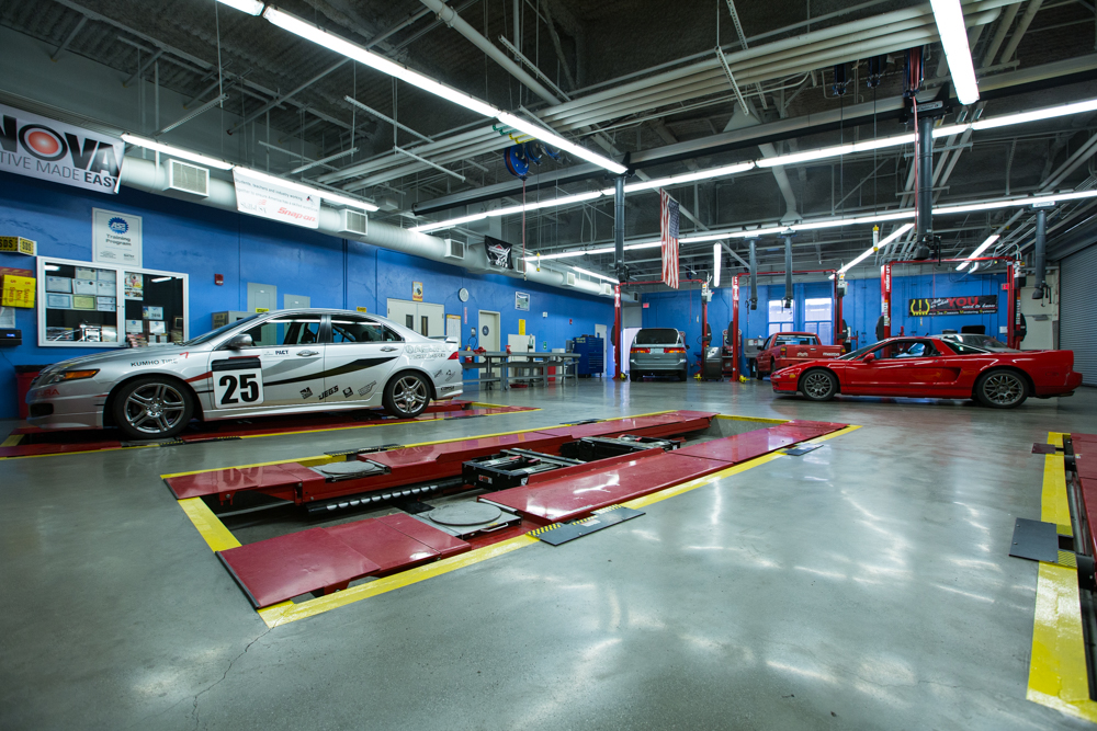 Wide-angle view of Río Hondo Community College’s automotive technology center, showcasing parked cars, organized tools, and diagnostic stations throughout the facility