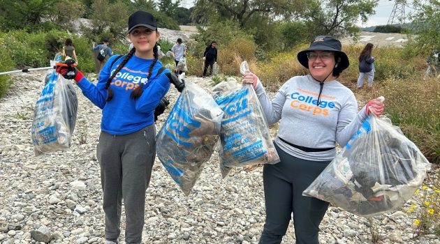 Students holding bags of trash from cleanup